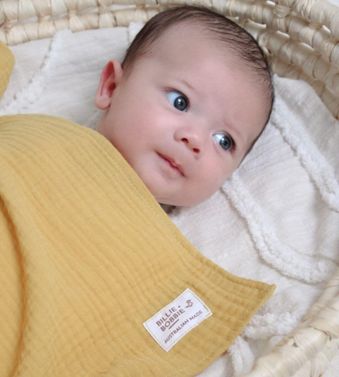 baby in mustard swaddle wrap